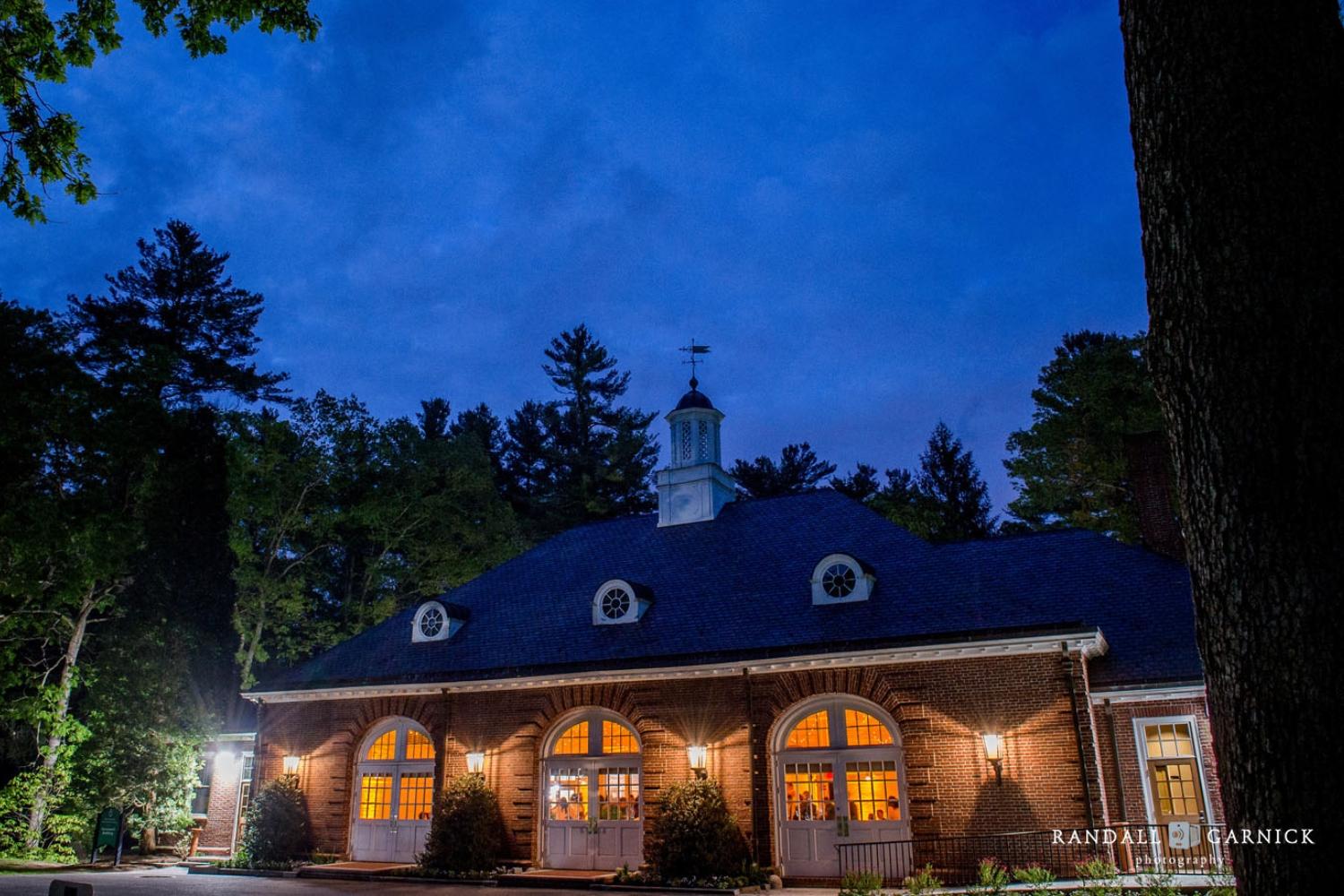 Evening photograph of lit-up Hunnewell Building located at The Garden at Elm Bank in Wellesley, MA