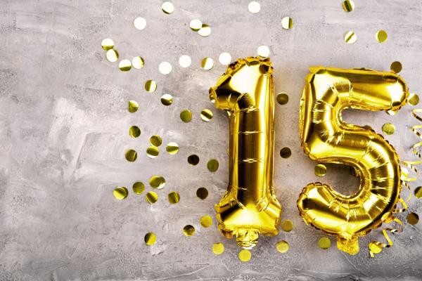 Photograph of helium filled gold 1 and 5 balloons with gold sparkly confetti surrounding them